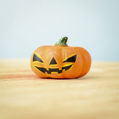 Large wooden Halloween pumpkin with a jack-o'-lantern face.