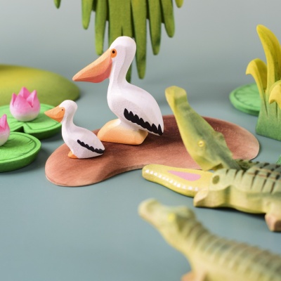 Crocodile family in wetland play scene with pelicans