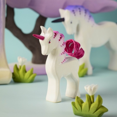 Baby Unicorn Pastel exploring a fantasy play scene with trees and flowers.