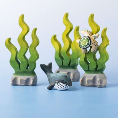 Baby Blue Whale next to green seaweed and a turtle toy