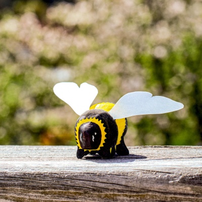 Wooden bumblebee toy on an outdoor wooden surface