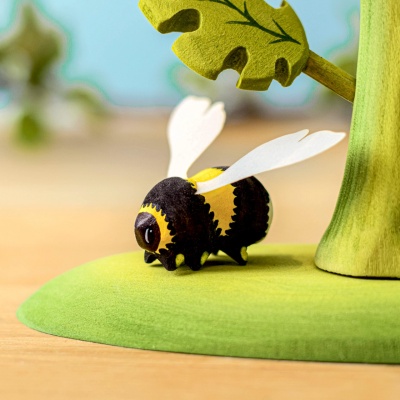 Multiple wooden bumblebees in a nest hanging from a branch