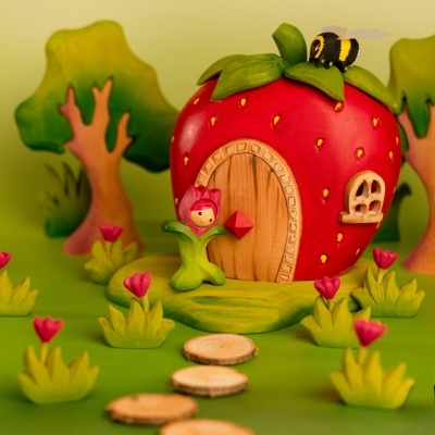 BumbuToys spring scene featuring the Flower Child Tulip standing next to the wooden Strawberry House.