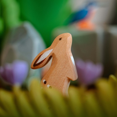 A charming wooden rabbit from BumbuToys, detailed with patterns and a heart, evoking curiosity.
