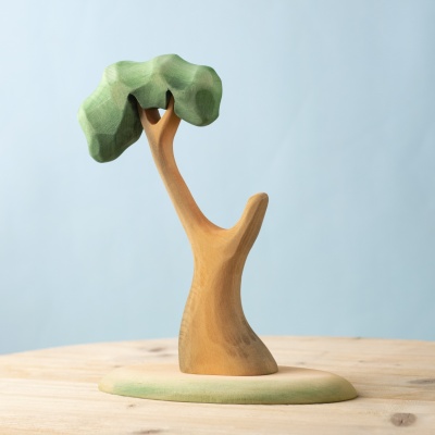 Handmade wooden eucalyptus tree with a green canopy on a wooden surface.