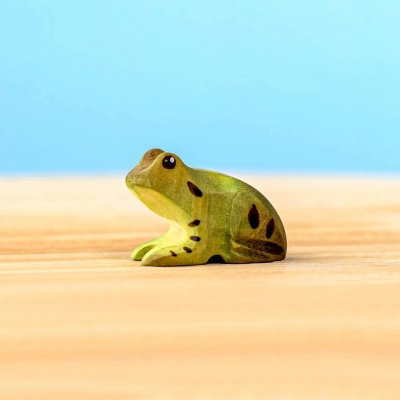 Close-up of a wooden frog figurine with detailed painting