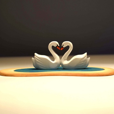 Artisanal wooden swans in love, perfect for educational play.