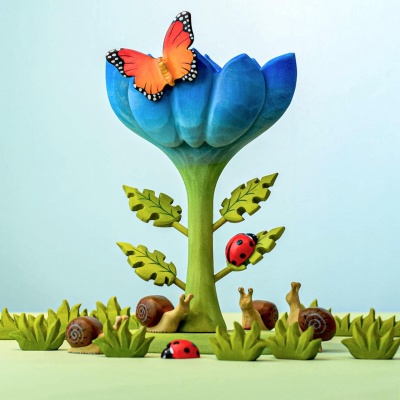 Colorful wooden toy scene with a blue flower, ladybugs, snails, and a butterfly by Bumbu Toys