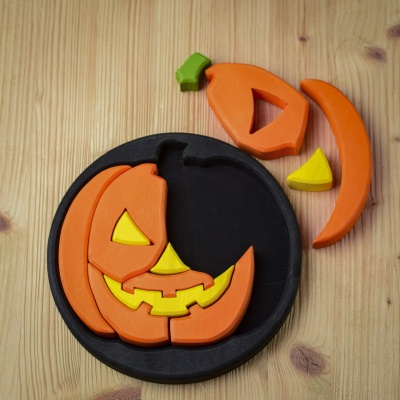 Round Halloween puzzle with pieces partially disassembled, showcasing the jack-o'-lantern face.