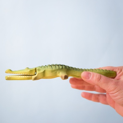 Crocodile with open mouth near play animals and reeds