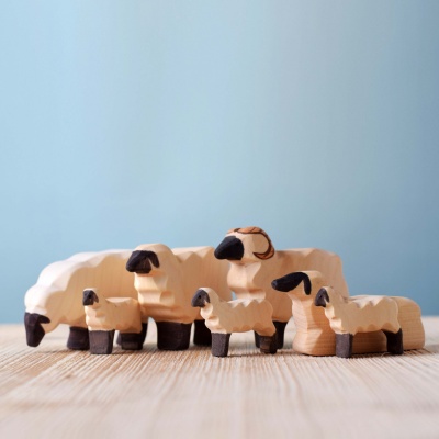 The sheep figurine displayed on a shelf in a child's room.