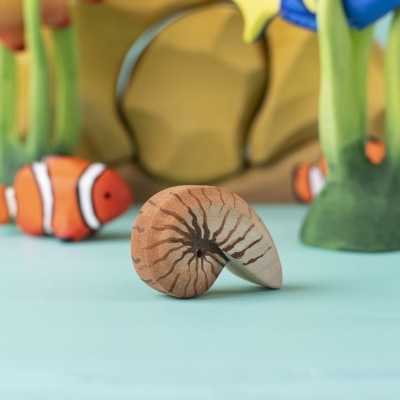 Spiral shell toy placed in an underwater play scene with coral and clownfish
