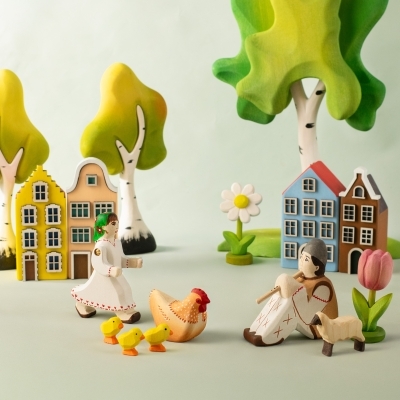Close up of a yellow wooden daffodil toy standing securely on a green wooden display base