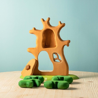 The treehouse being used in a counting or sorting activity with other nature-themed toys.