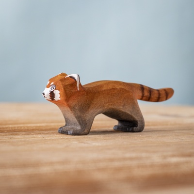 Crawling red panda wooden figure on wooden surface