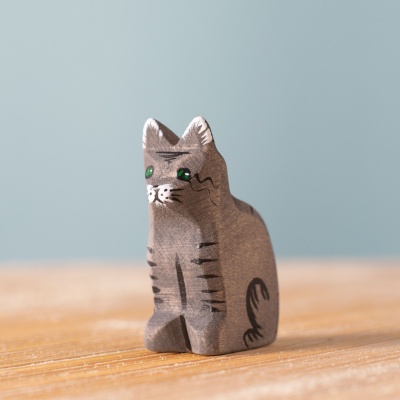 The wooden Cat toy on a light-colored table in a bright, airy room.