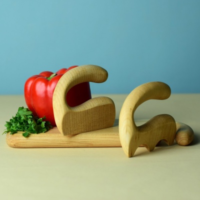Wooden chopper and salad spatula with cutting board and vegetables