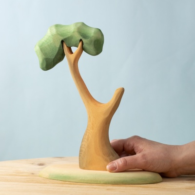 Wooden eucalyptus tree held by hand, showing its size and natural shape.