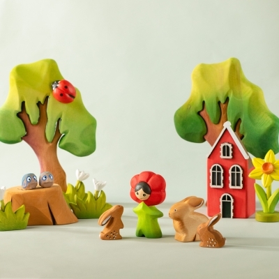Whimsical woodland scene with wooden trees a red house bunnies a fairy and a yellow daffodil