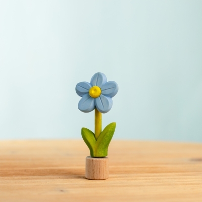 Single blue handcrafted wooden toy forget-me-not standing upright