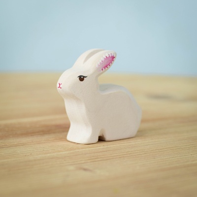 Handcrafted wooden Sitting Easter Rabbit on a wooden surface.