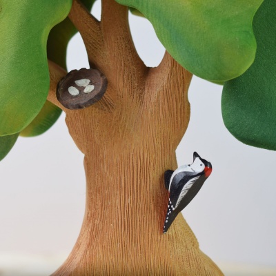 BumbuToys' Woodpecker pecks away on the Large Green Oak, beside a snugly crafted nest.