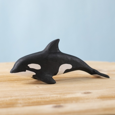 Wooden Orca toy on a wooden surface
