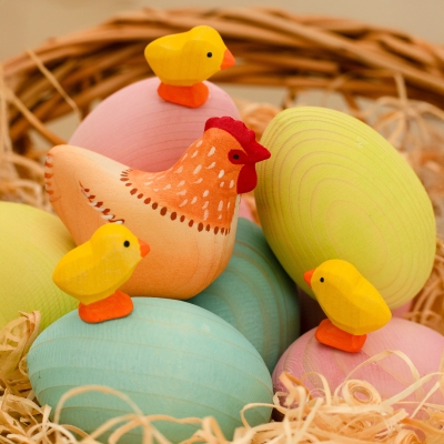 Festive Easter table setting with candles and pastel wooden eggs in a basket