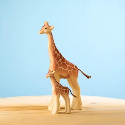 Wooden giraffe calf toy with a larger giraffe on a wooden surface.