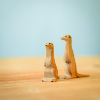 Handcrafted wooden meerkats standing on a wooden surface by Bumbutoys