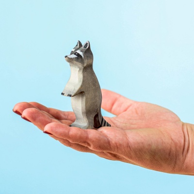 Hand holding Wooden Curious Raccoon for size reference