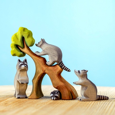 Wooden raccoon climbing a tree in a play scene