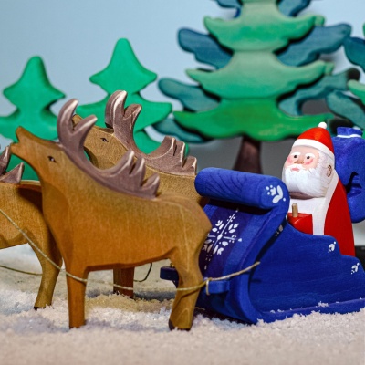 The stag toy integriert into a pretend play scenario with a wooden toy truck or cart.