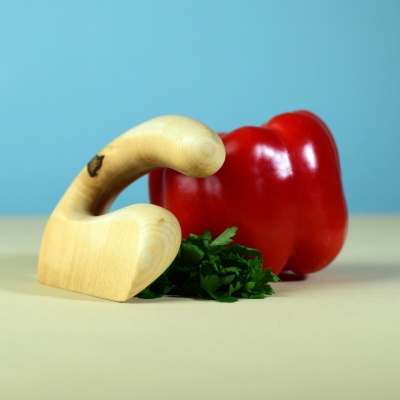 Wooden chopper with a red bell pepper and parsley