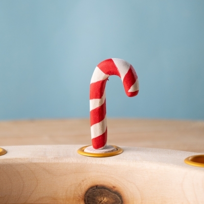 Festive Candy Cane displayed on wooden celebration ring.