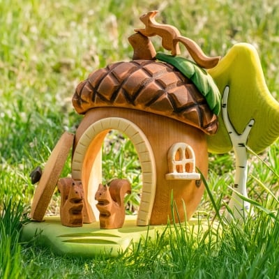 Child hands removing the brown wooden roof from the puzzle-like acorn house toy