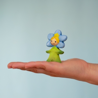 Adult hand holding the wooden Flower Child Forget-Me-Not to demonstrate the 7cm height and smooth finish.