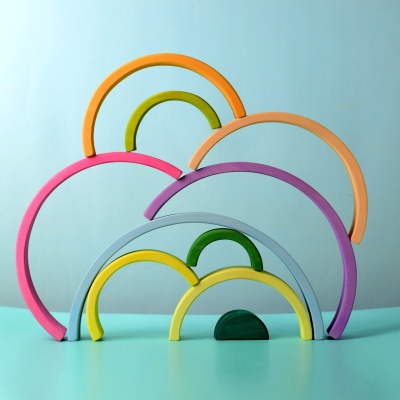 Creative play scene with Large Rainbow wooden arches arranged in different shapes.