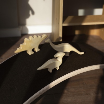 Close-up photo of a handcrafted wooden Parasaurolophus dinosaur toy