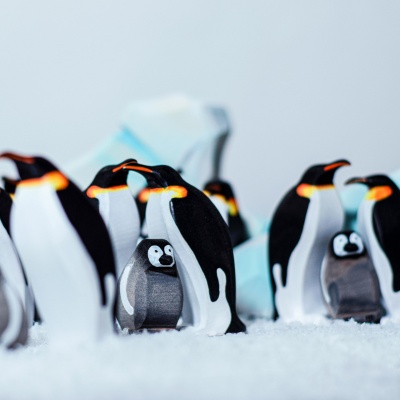 Realistic wooden figures of Emperor Penguins by BumbuToys, reflecting nature's design.