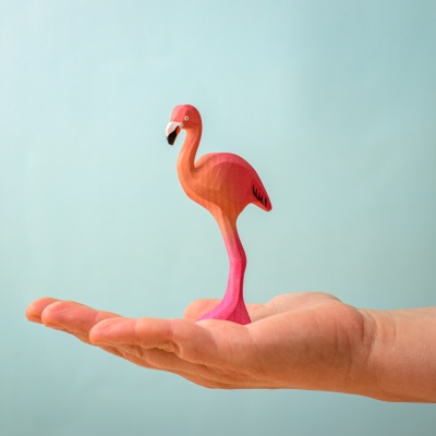 Hand holding the Flamingo wooden toy.