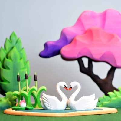 Sustainable wooden love symbol decor featuring swans on a heart lake.