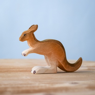 Handmade wooden kangaroo toy standing on a wooden surface