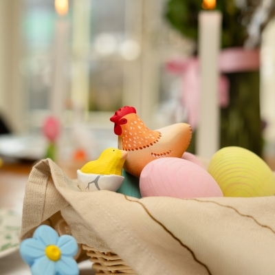 Spring play scene with wooden birch trees, traditional Romanian figures, and a pastel pink wooden egg