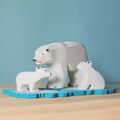 Handcrafted polar bear figures from BumbuToys, exploring a wooden ice floe.