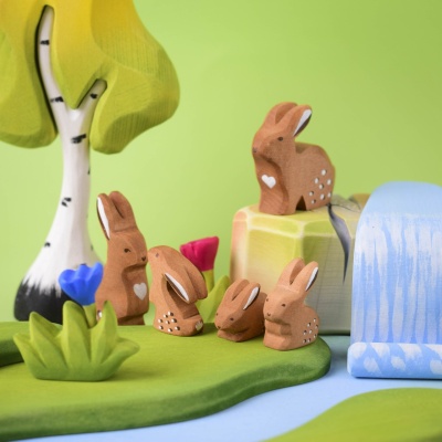 Close-up of handcrafted wooden bunnies in a playful setup.