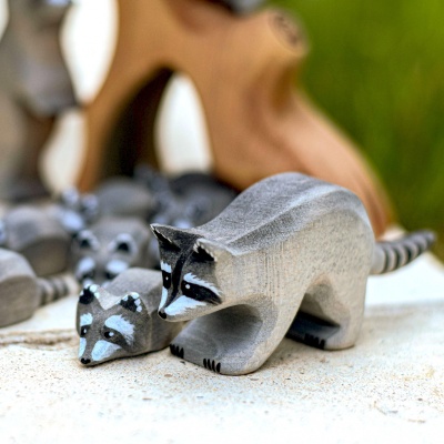 Close-up of wooden raccoon figures in a play environment
