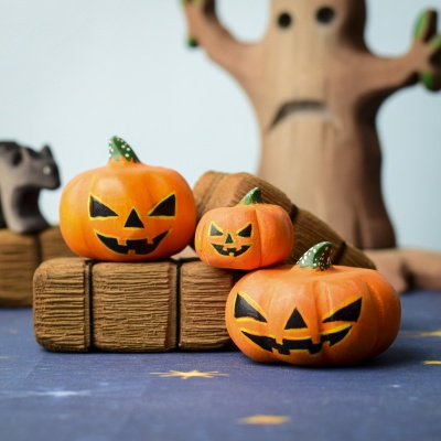 Halloween pumpkins set in a spooky scene with other wooden toys.