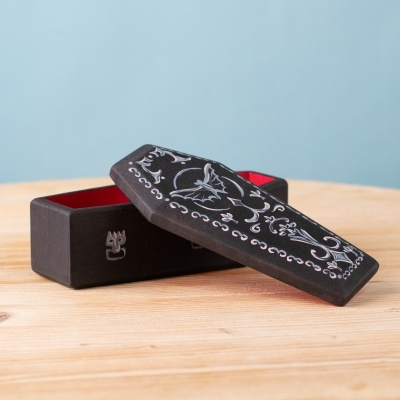 Black wooden coffin with lid slightly open, red interior visible