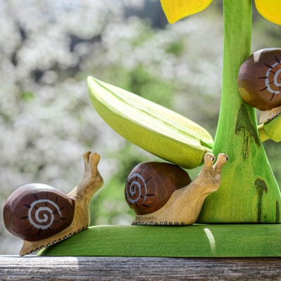 Wooden snails on a sunflower
